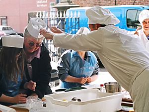Photo: Paul gives a visitor a hat